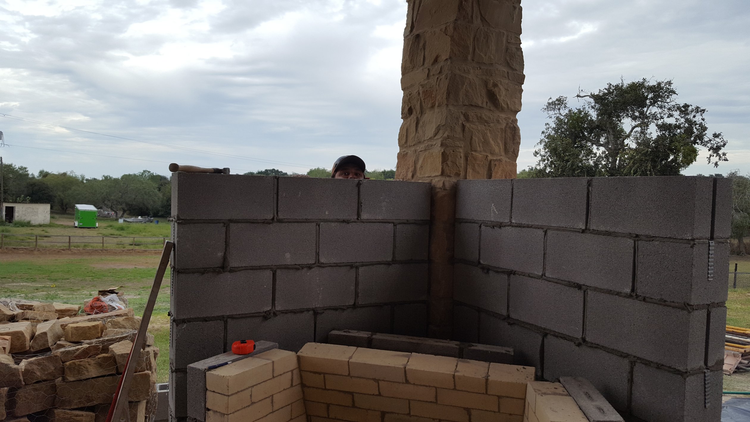 Coastal Masonry team building outdoor fireplace. 